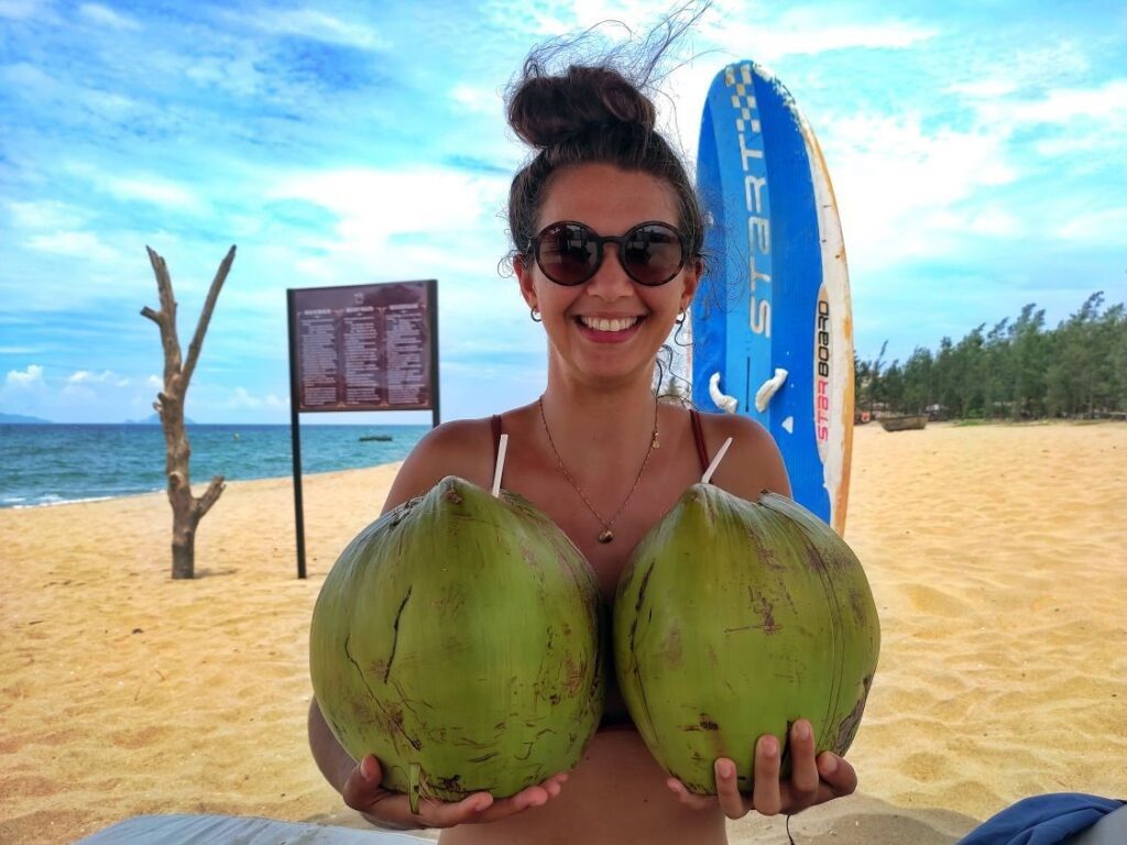 Mit Kokosnuss am Strand